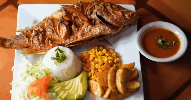 Plate with a whole fried fish and sides