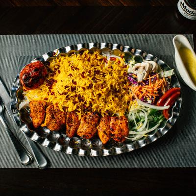 Grilled chicken skewers, with rice, and salad.
