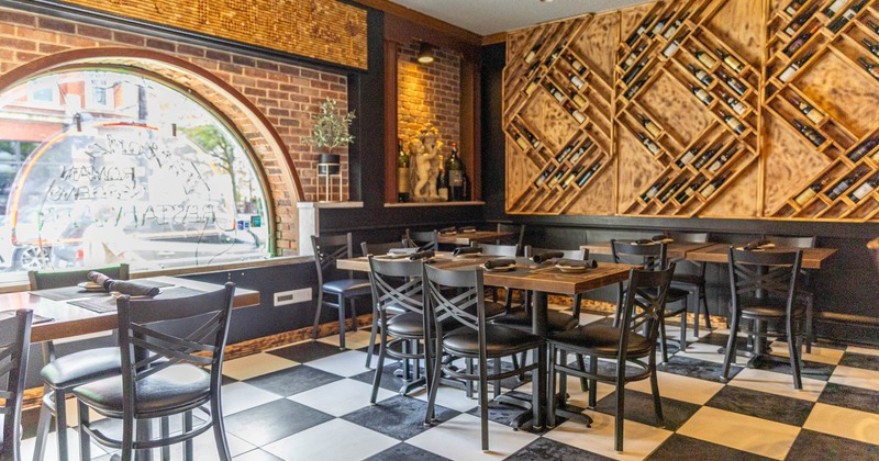 Cozy restaurant interior with checkered floors, wooden tables, and a wine bottle display on the wall