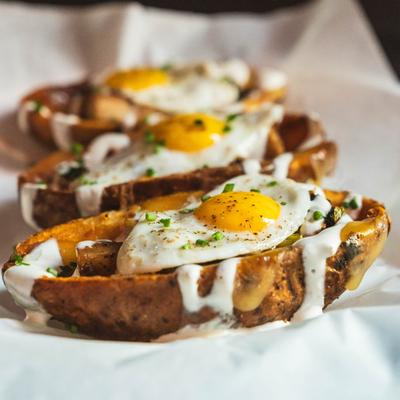 Potato skins, with pork belly, gouda, charred scallion cream, quail eggs, and chives.