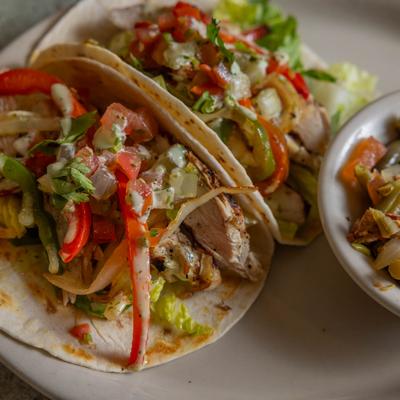 Chicken fajita tacos served with side veggies.