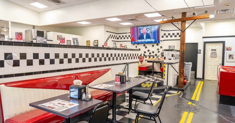 Diner interior with red booths and black tables
