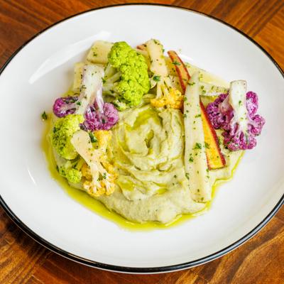 Roasted cauliflower florets and carrots served over pale green puree.