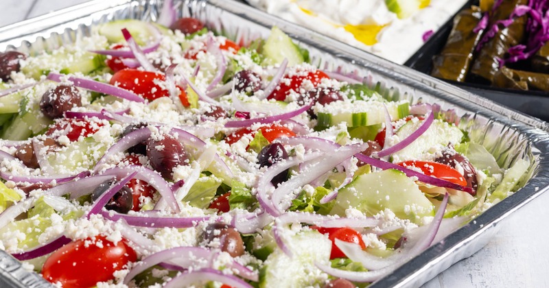 A large catering tray with Greek salad