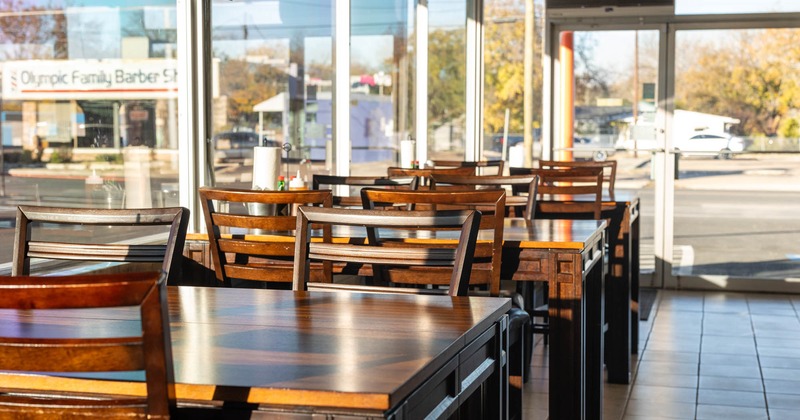 Interior, dining area, tables and chairs by the windows