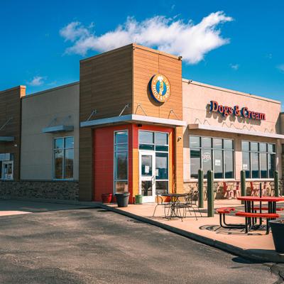 Restaurant building and outdoor seating with picnic tables and small dining sets.