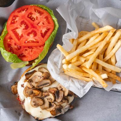Mushroom Swiss burger with lettuce, tomato, and fries.