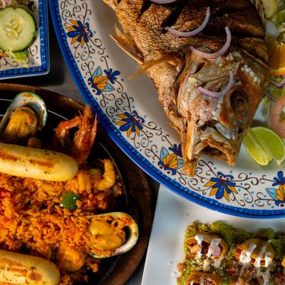 Whole fried fish served with seafood paella.