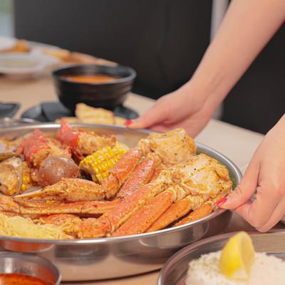 Hands holding the snow crab bucket meal.