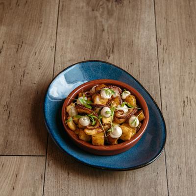 Grilled octopus with diced potatoes, mayo, and herbs.