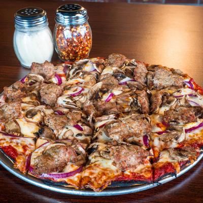 The Classic Pizza alongside shakers of parmesan cheese and red pepper flakes.