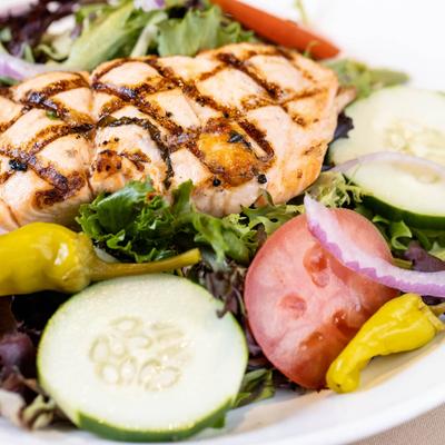 Texas Salad, with grilled salmon, greens, tomatoes, cucumber, peppers, and red onions.