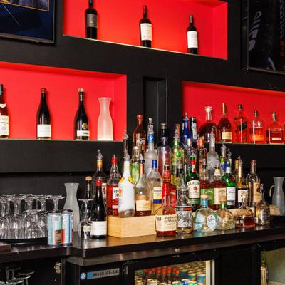 Assorted liquor bottles arranged on a bar counter.
