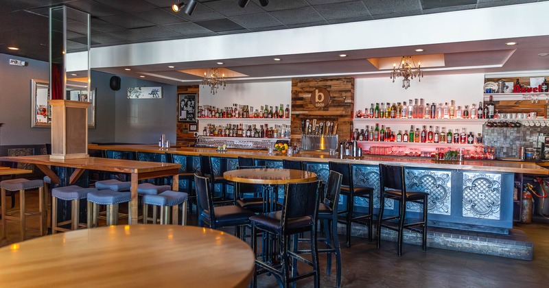 Interior, tables and chairs with bar in the back