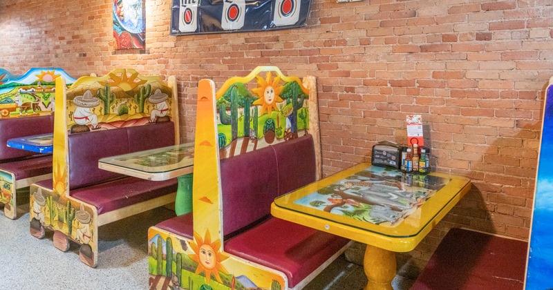Interior, seating area with booths and tables near the wall