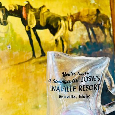 Painting with horses, deformed beer glass reading “You Are Never a Stranger”.