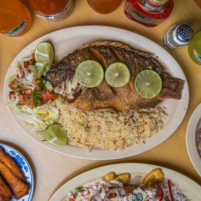 Grilled fish topped with lime served with rice and salad.