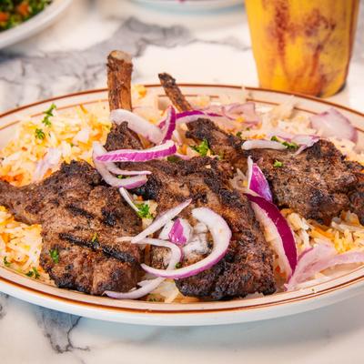 Grilled lamb chops on seasoned rice, topped with red onions.