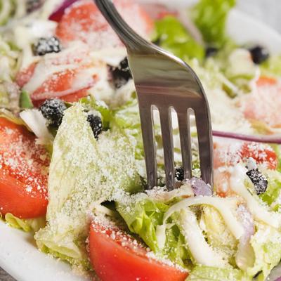 Fork taking a bite of Tossed Salad, close-up.