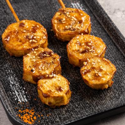 Glazed sweet potato skewers with sesame seeds.