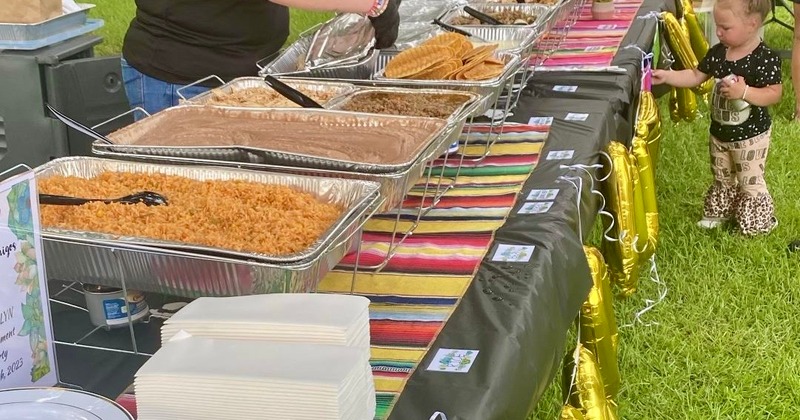 Catering dishes with rice, refried beans, and tortillas