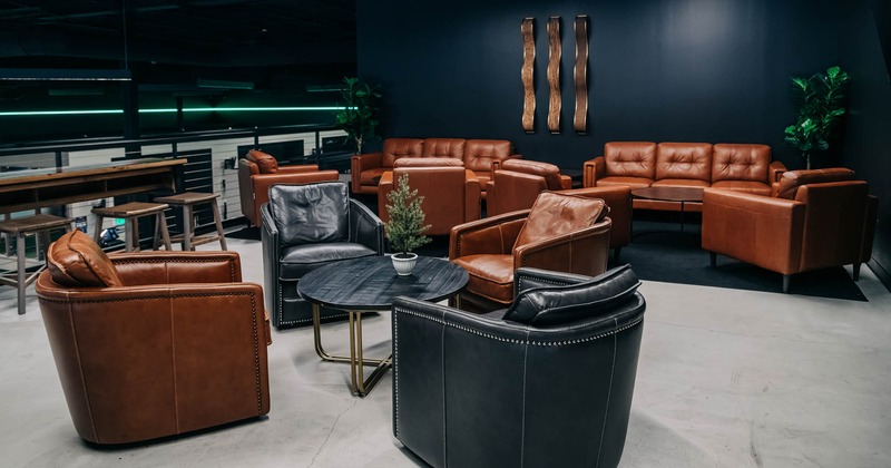 Interior, lounge area, leather padded armchairs with coffee table, sofas in the back