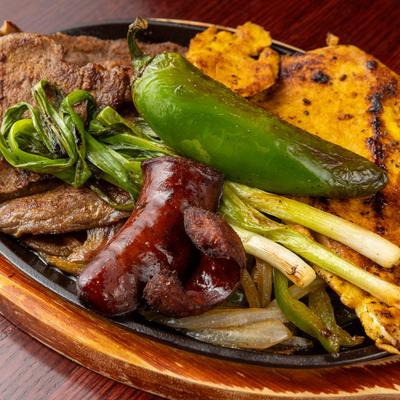 Grilled steak, chicken, sausage, peppers, and onions.