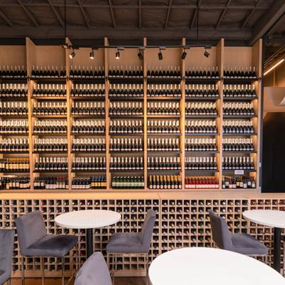 Wine bar interior with stocked shelves and modern seating.