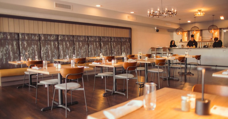 Interior, tables for two, and high back bench seating by the wall