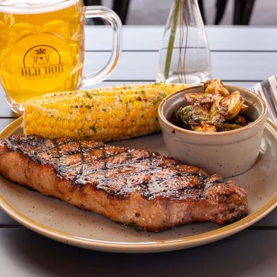 New York strip with potato salad and corn on the cob