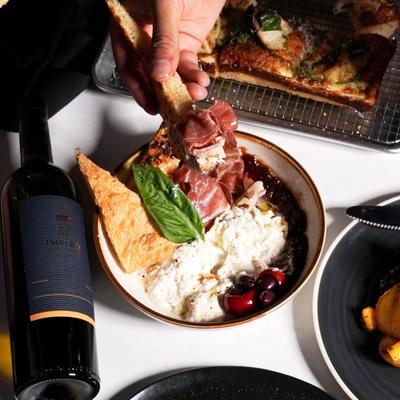 Prosciutto and Brie Cheese Spread, various dishes, and a bottle of wine.