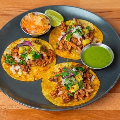 Marinated pork tacos, with onion, cilantro, and pineapple salsa.