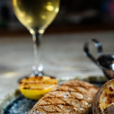 Griled Mahi-mahi fish with a glass of white wine.