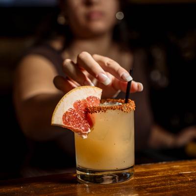 Bartender putting staw into a cocktail.