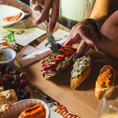 A well-set table displaying a variety of delicious food items, people sharing a crostini board.
