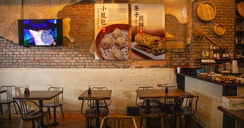 Interior, dining area, wooden top tables with metal chairs, vintage brick wall