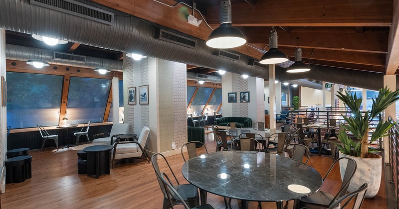 Interior, upstairs seating area, round table for eight, armchairs and tables in the back