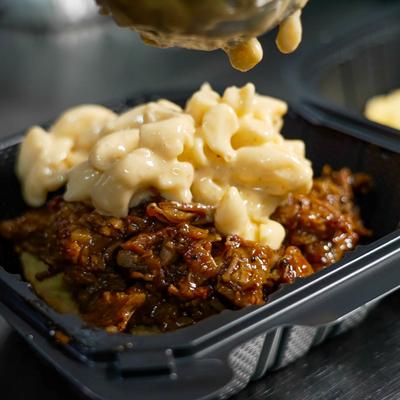 Brisket mac and cheese in a takeout container.