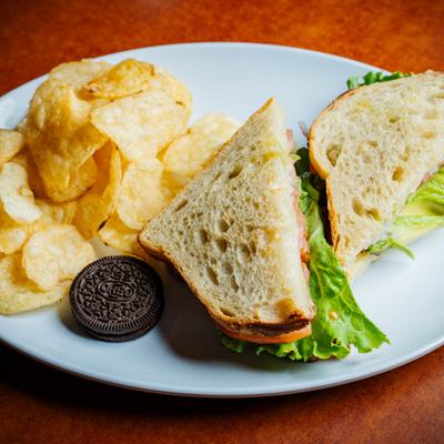 Californian sandwich served with potato chips and a cookie.