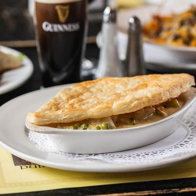 Chicken pot pie served with a pint of dark beer.