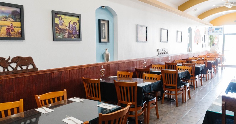 Interior, seating area, tables for four, ready for guests, tile flooring