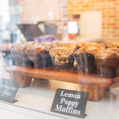 Muffins in a glass display case.