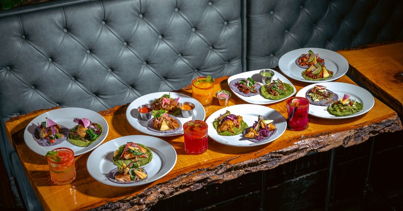 Interior, leather banquette with  a live edge table spread with food and drinks