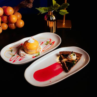 Mango guava cheesecake and blueberry tart served on white plates.