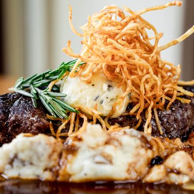 Grilled sirloin with tomato, herb mashed potatoes and green harissa.