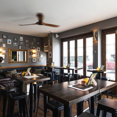 Cozy and rustic interior seating area with high tables and stools.