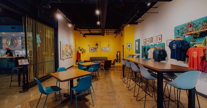 Interior, seating area, tables for four, high community table, lounge area in the back