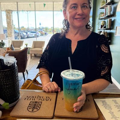 Customer holding a Warrior Fuel tea at the bar.