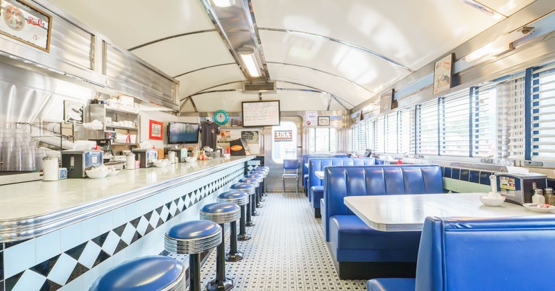 Interior seating area with bar stools, double booths and tables
