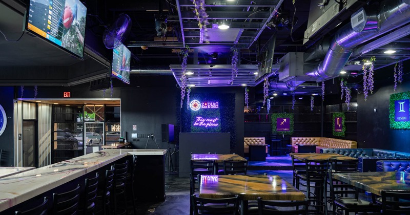Interior, wide view, tables and chairs on the right, bar and bar stools on the left
